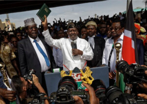 “Opposition leader Raila Odinga raises a Bible while taking an oath during a symbolic ‘swearing-in’ event at Uhuru Park in central Nairobi, Kenya.